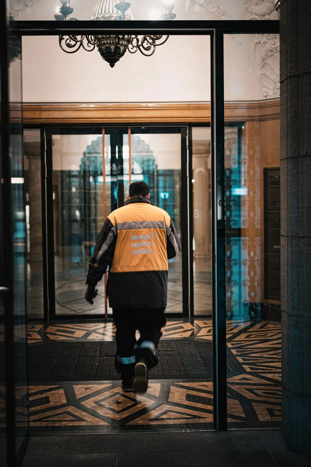 Two workers cleaning windows on a glass building facade using a lift platform, enhancing building aesthetics.